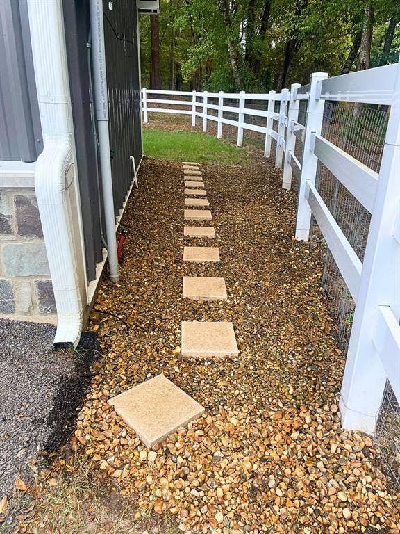 16713 Creek Bottom Court, Winona, TX 75792 White picket fence, gravel pathway, stepping stones, dark siding, stone foundation