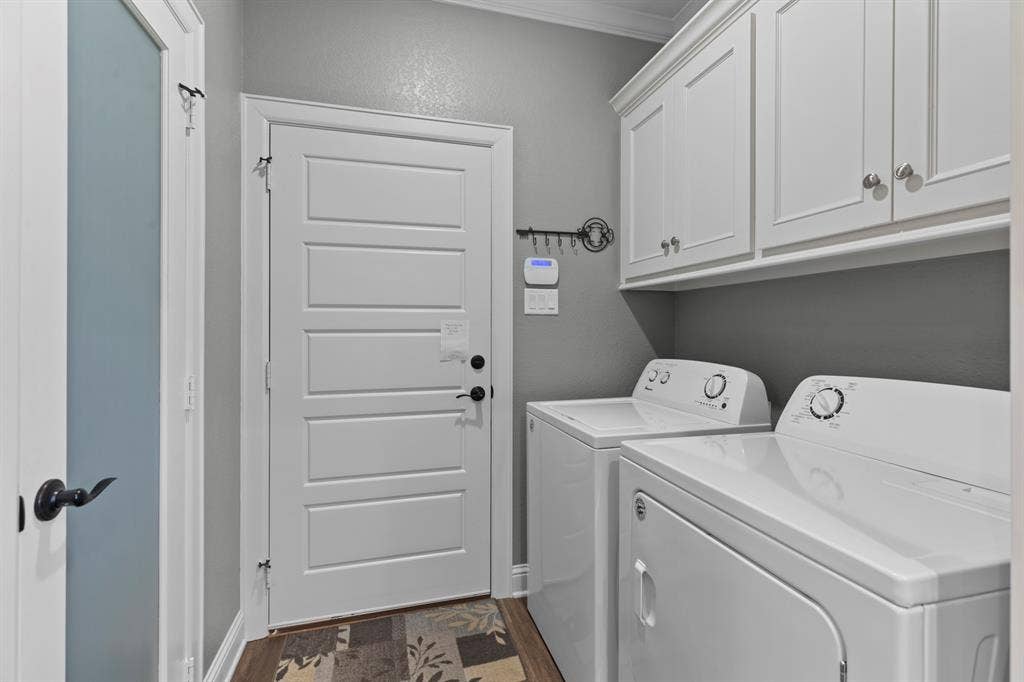 16713 Creek Bottom Court, Winona, TX 75792 White shaker-style cabinetry with crown molding, solid-core interior door, and wood-finish flooring