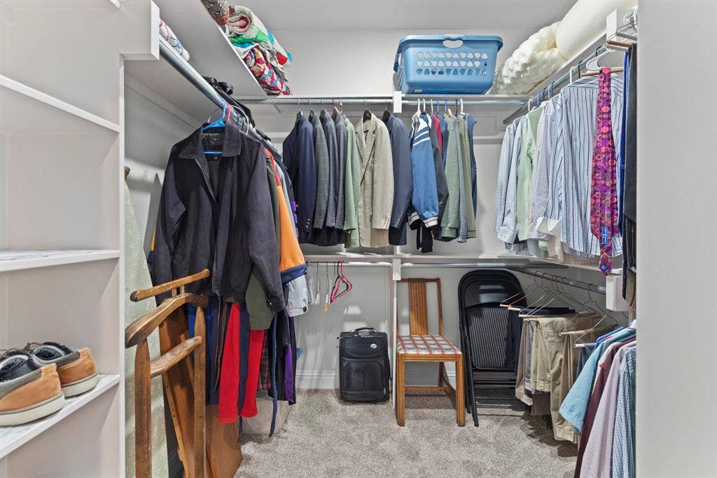 16713 Creek Bottom Court, Winona, TX 75792 Integrated shelving system with multiple hanging rods, white built-in shelving, and light gray carpeting