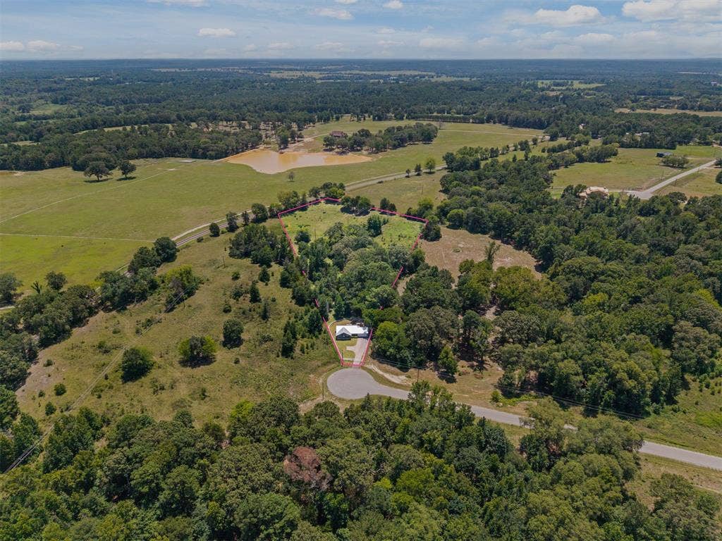 16713 Creek Bottom Court, Winona, TX 75792 Expansive rural landscape featuring a private residence, mature tree cover, and open grassy areas