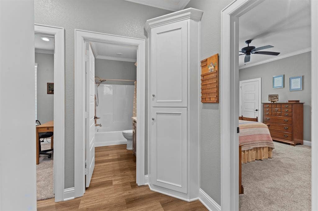 16713 Creek Bottom Court, Winona, TX 75792 Hallway featuring wood-finish flooring, built-in white cabinetry, and crown molding