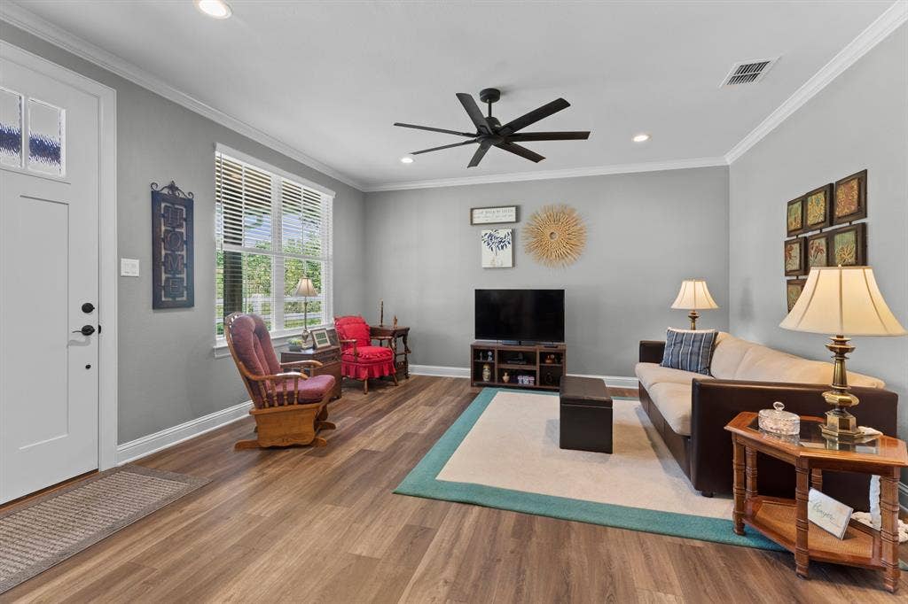 16713 Creek Bottom Court, Winona, TX 75792 Wood-finish flooring, a ceiling fan with integrated lighting, recessed ceiling lights, a window with blinds, and white crown molding