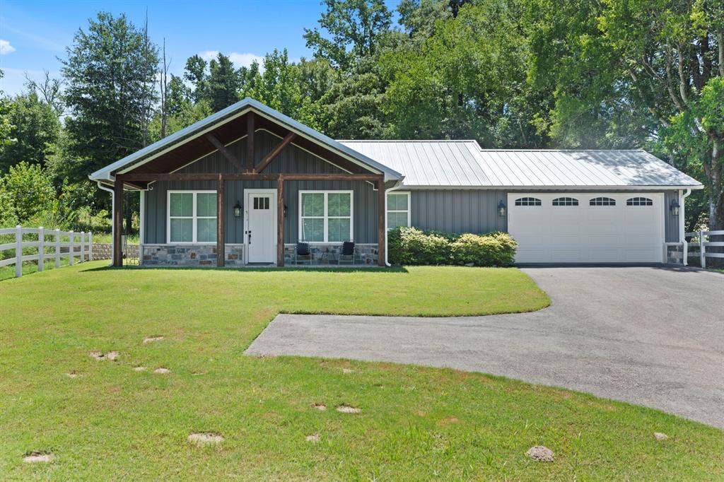 16713 Creek Bottom Court, Winona, TX 75792 Modern farmhouse exterior with board and batten siding, stone facade, and a metal roof