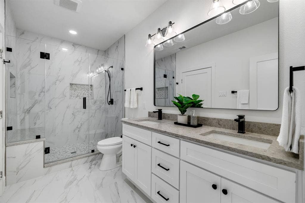 4402 Briargrove Lane, Dallas, TX 75287 4402 Briargrove-Dual sink vanity with stone countertop, large rectangular mirror, and matte black fixtures
