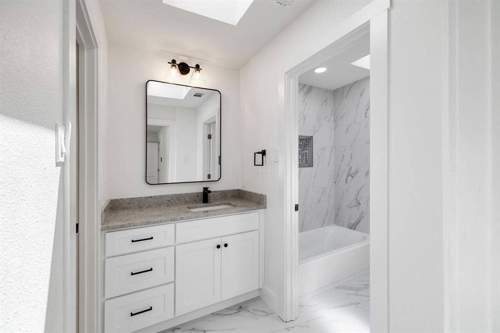4402 Briargrove Lane, Dallas, TX 75287 4402 Briargrove-White vanity with a light-toned countertop, rectangular sink, and matte black fixtures