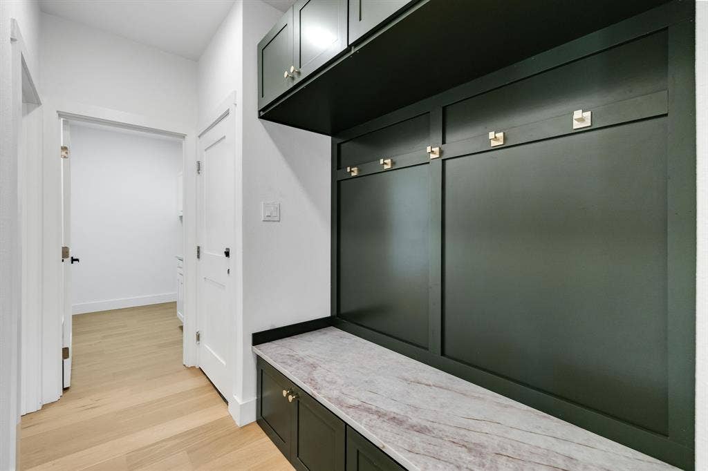 4402 Briargrove Lane, Dallas, TX 75287 4402 Briargrove-built-in hall storage featuring rich green cabinetry, gold-tone hardware, and a Taj quartz bench top.
