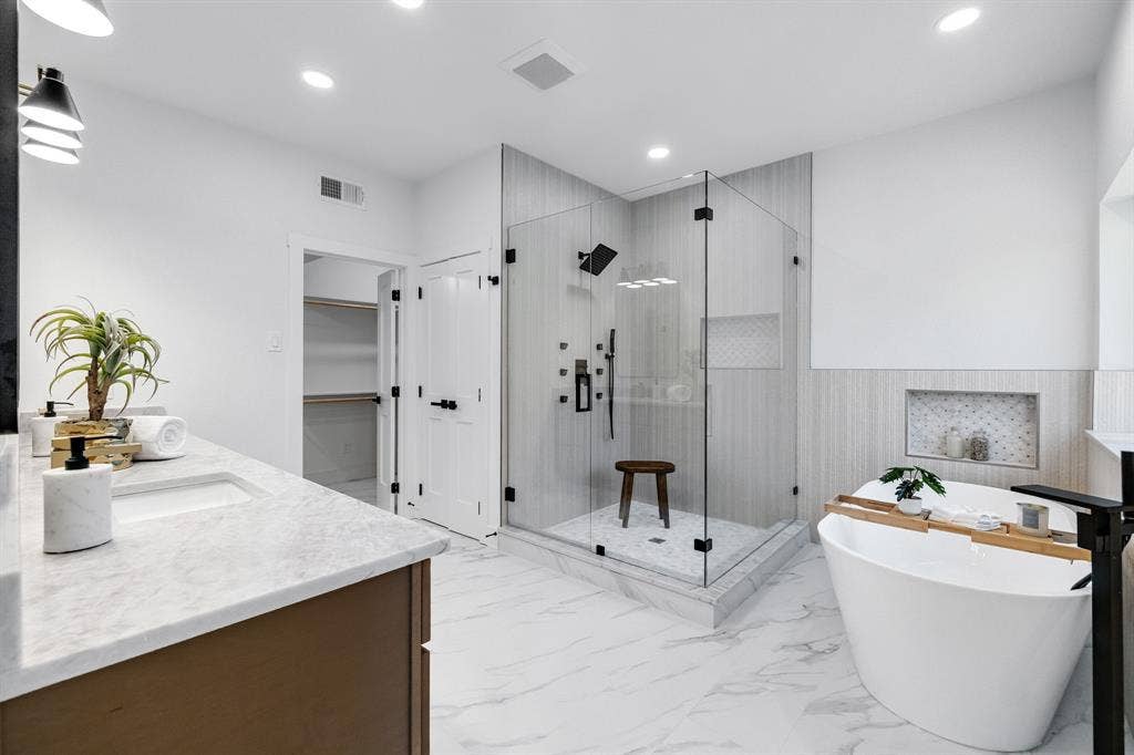 4402 Briargrove Lane, Dallas, TX 75287 4402 Briargrove-Spa-inspired primary bath featuring a glass-enclosed shower with multiple sprayers, freestanding soaking tub, and custom vanity topped with Taj quartz.