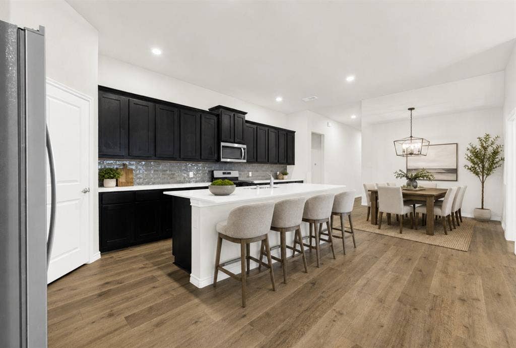 This unique view from the edge of the large refrigerator shows the seamless transition from the kitchen to the foyer. Getting groceries inside or unpacking supplies is a breeze when your kitchen is this central and accessible. *Virtually Staged*
