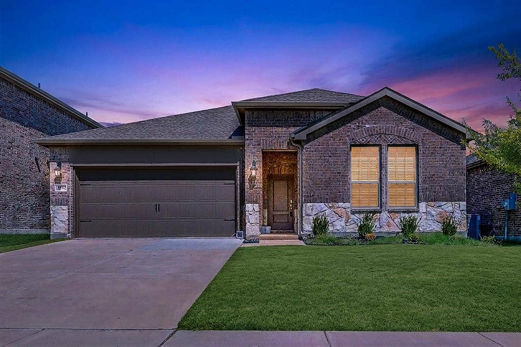 Welcome to 1932 Willie Ray in Anna.  Set against a colorful evening sky, this virtual twilight angle showcases exterior sconce lighting and glowing front windows framing the stone facade. Imagine pulling into your driveway after a long day to be greeted by this warm, welcoming aesthetic.