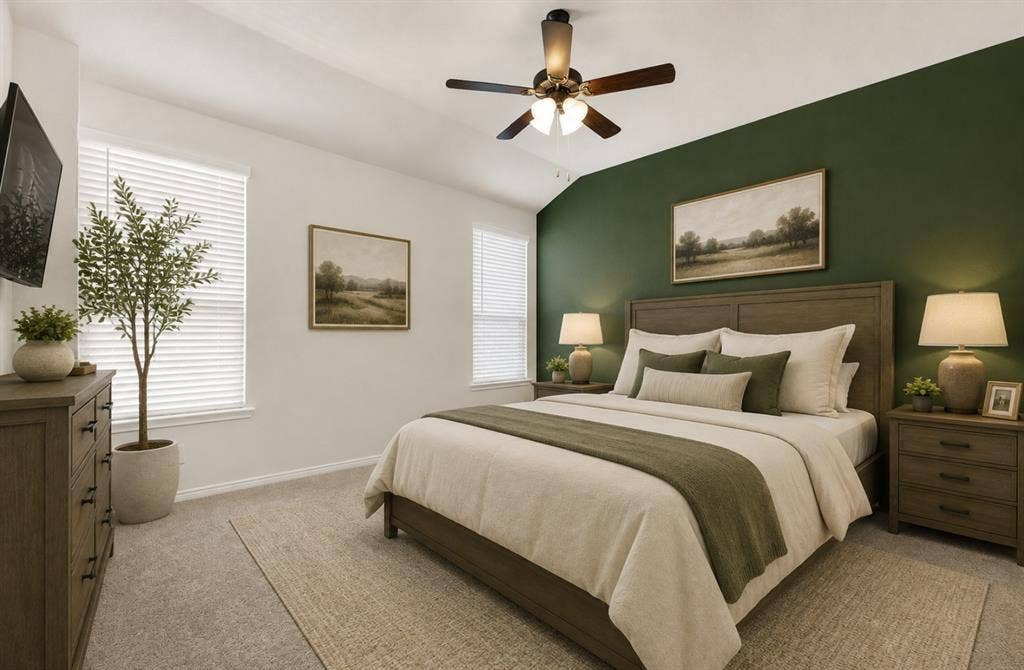 This angle of the primary suite showcases the soothing green accent wall that grounds the expansive, carpeted room beneath a vaulted ceiling and modern ceiling fan. It serves as a calm sanctuary where you can truly escape the day and recharge in peaceful comfort. *Virtually Staged*