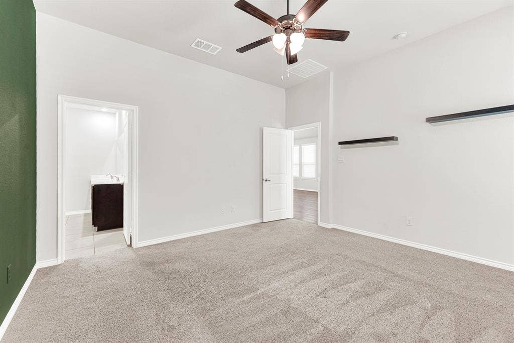 This viewpoint connects the peaceful bedroom area, including its wall shelves and ceiling fan, directly to the large window view and the entrance of the spa-inspired ensuite bathroom. Experience effortless luxury as you move freely between your private relaxation space and the well-appointed bathroom.