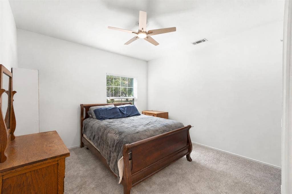 Carpeted flooring, window with blinds, ceiling-mounted fan, and white painted walls
