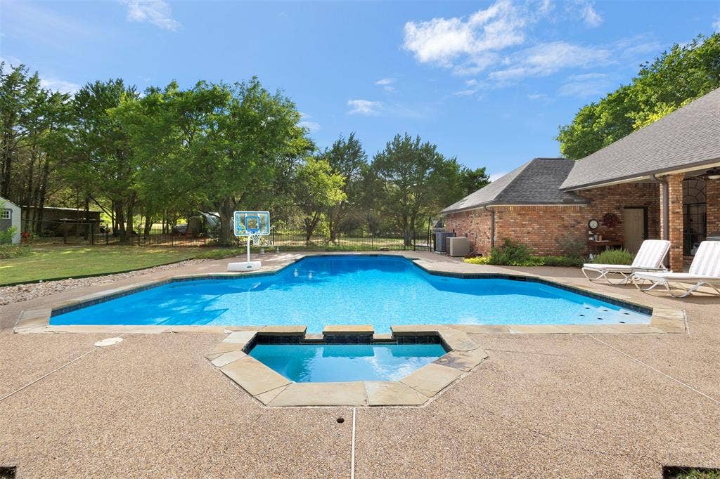 Swimming pool with integrated spa, surrounded by an exposed aggregate concrete deck
