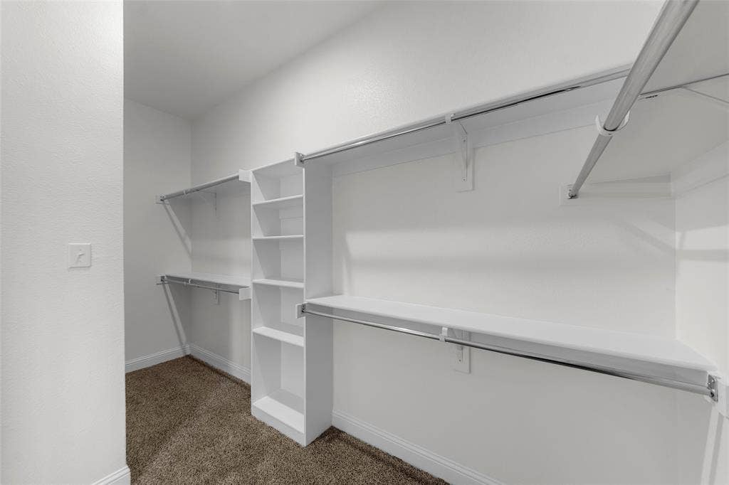 111 WATERCREST Lane, Glenn Heights, TX 75154 Walk-in closet with carpet flooring, white shelving, and chrome hanging rods