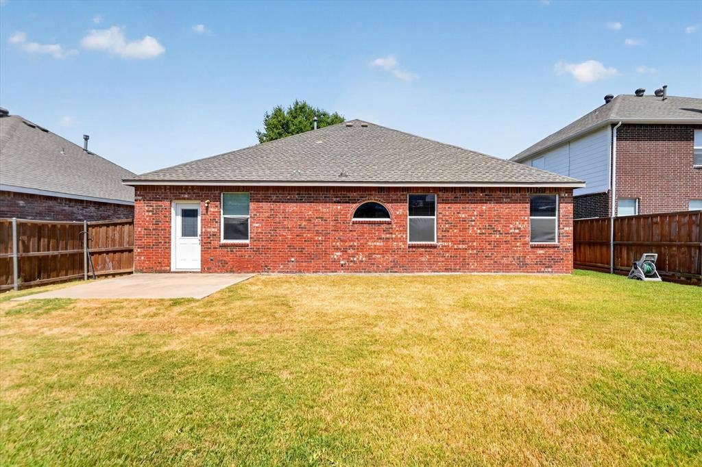 6513 Cartier Court, McKinney, TX 75072 Expansive backyard with a large grass lawn, privacy fencing, and a concrete patio