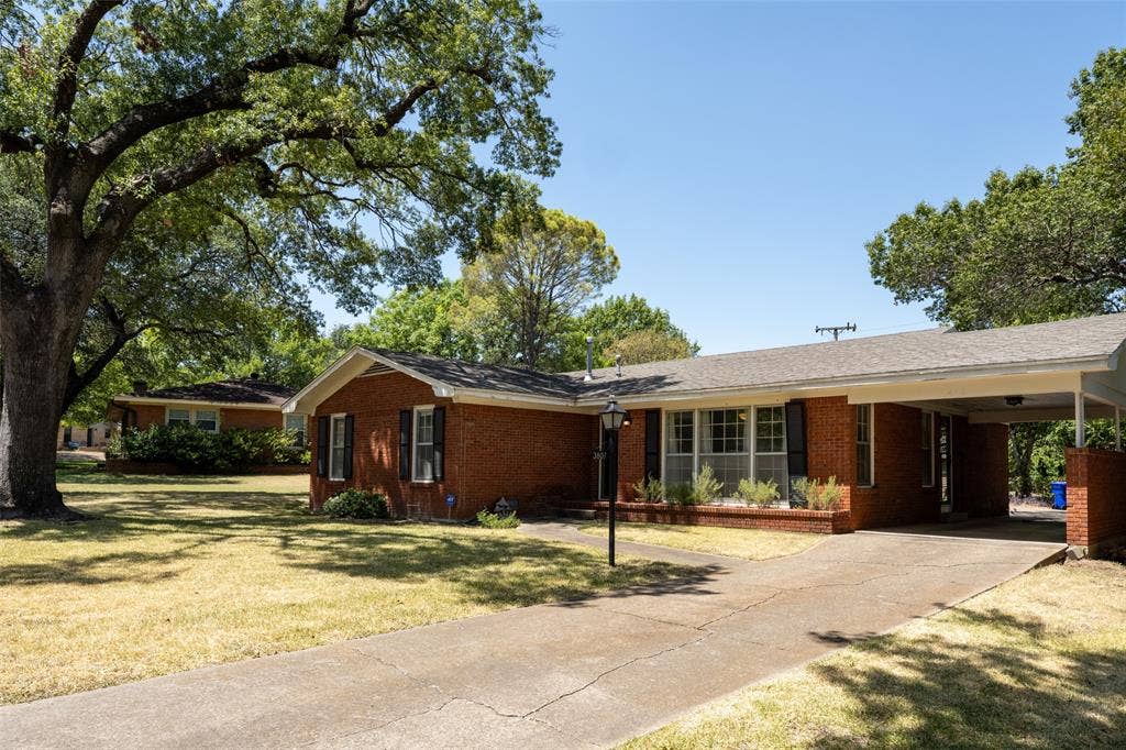 3807 Huaco Lane, Waco, TX 76710 Brick exterior residence featuring a carport, mature tree, and established landscaping