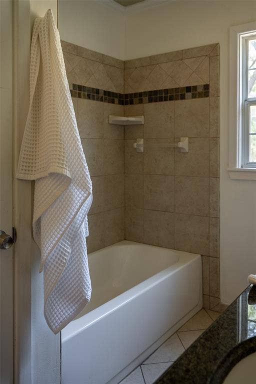 3807 Huaco Lane, Waco, TX 76710 Tiled bath surround with mosaic accent, white built-in bathtub, and window