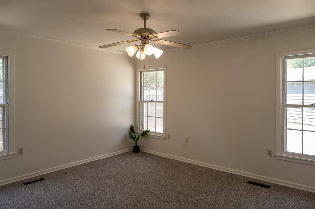 3807 Huaco Lane, Waco, TX 76710 White walls, two large windows, textured carpeting, and a ceiling fan with integrated lighting