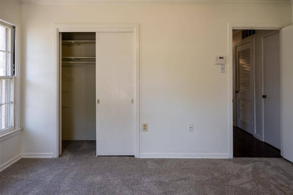 3807 Huaco Lane, Waco, TX 76710 Wall-to-wall carpeting, window with grid panes, sliding closet doors, built-in closet shelving, and white baseboards