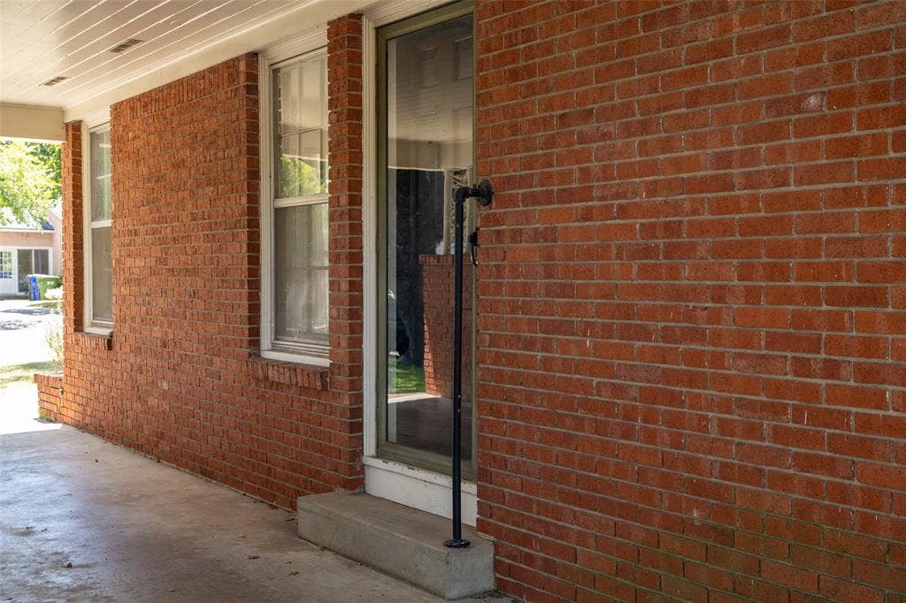 3807 Huaco Lane, Waco, TX 76710 Brick exterior with a covered porch, multiple windows, and a glass-paneled entry door