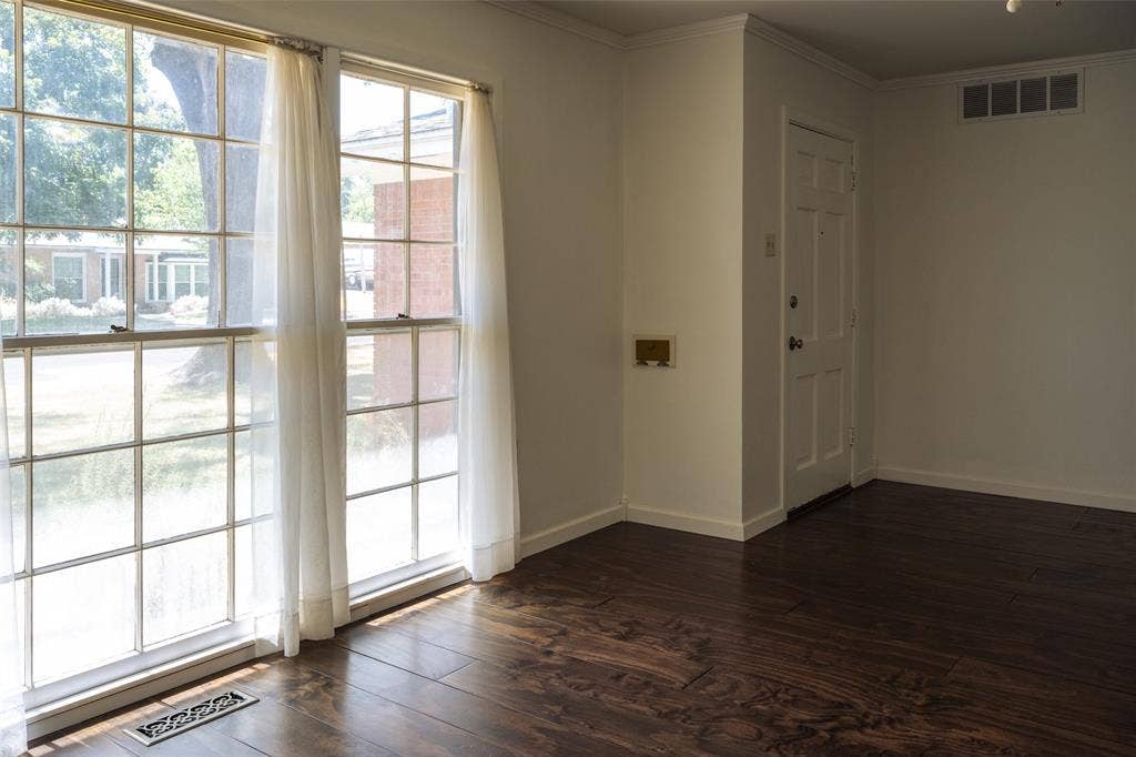3807 Huaco Lane, Waco, TX 76710 Bright, light-filled living space featuring expansive multi-pane windows with natural light, dark wood-finish flooring, and clean, neutral walls