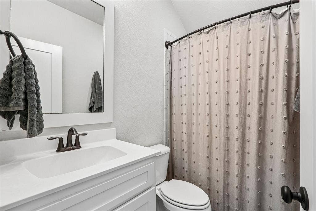 1657 Lilac Lane, Celina, TX 75009 White vanity with integrated sink, bronze-finish faucet, and coordinating mirror