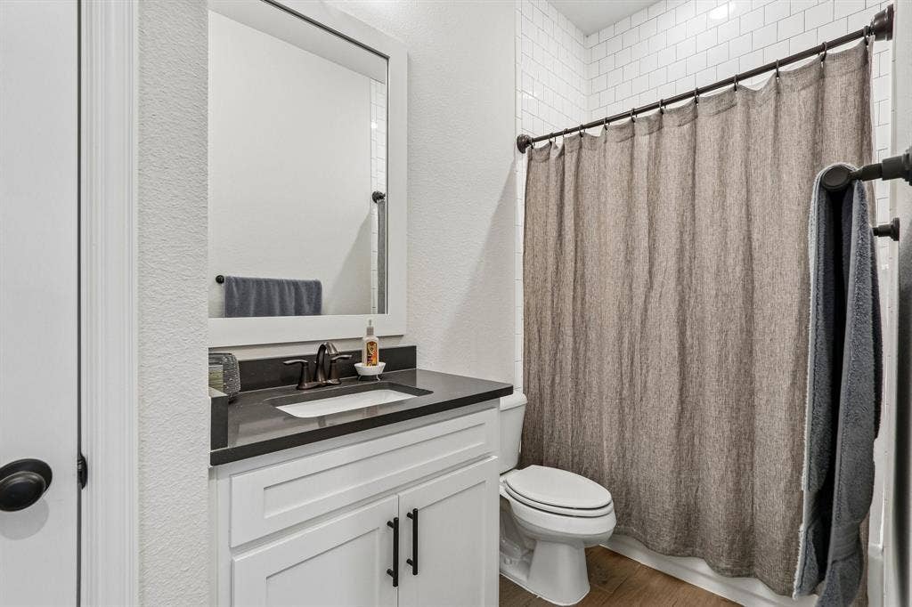 1657 Lilac Lane, Celina, TX 75009 White vanity with dark countertop, rectangular undermount sink, and dark bronze fixtures