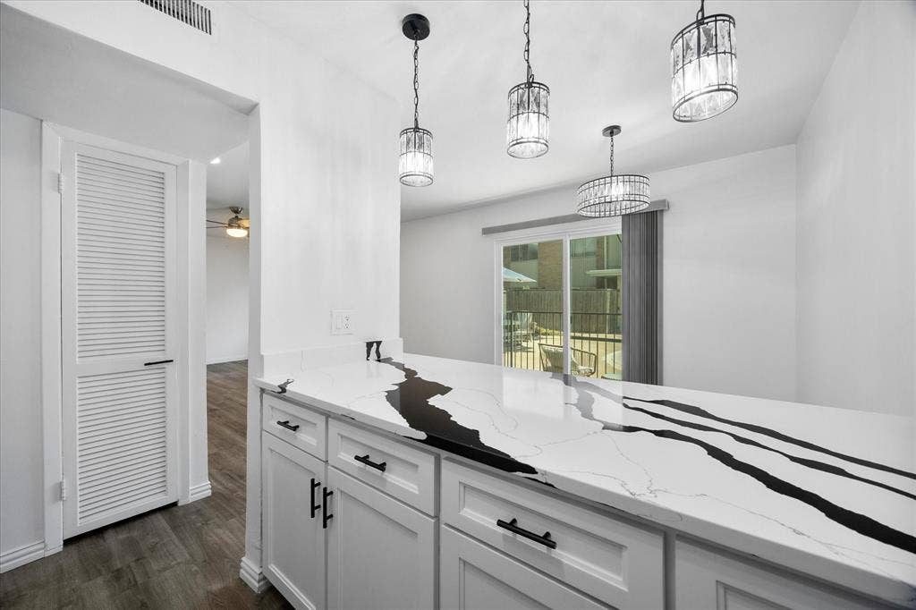 4011 Cole Avenue, #111, Dallas, TX 75204 Kitchen with updated finishes and views toward the dining area, courtyard and pool.