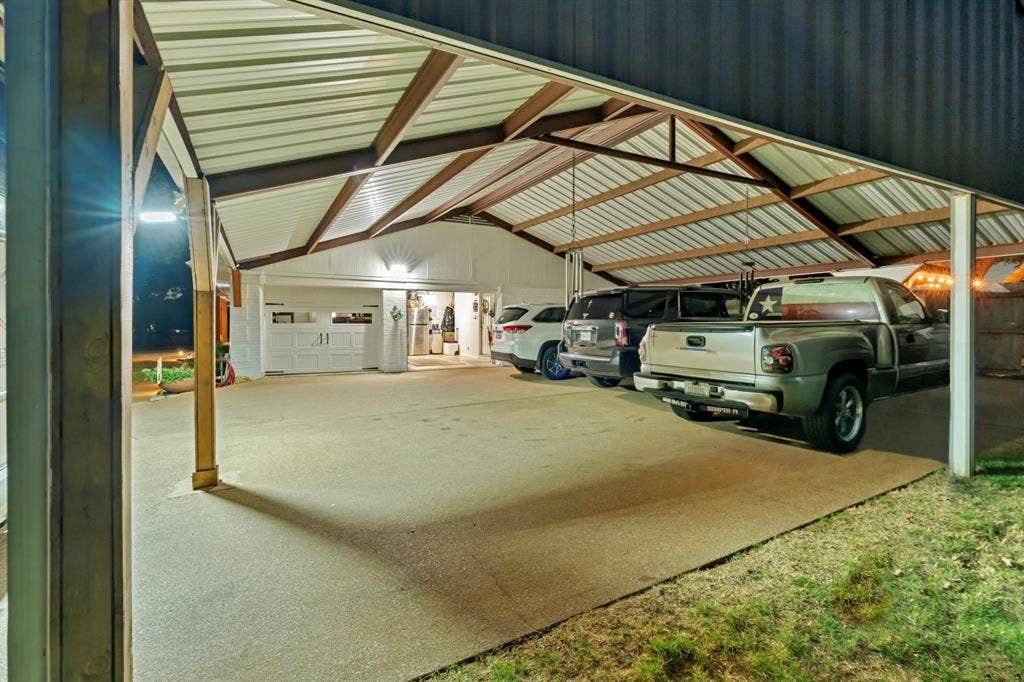 6155 Stephenson Levy Road, Fort Worth, TX 76140 This solid steel carport off of the main home- allows for six vehicles to be fully covered from the elements - while still offering great covered storage as seen in the lit areas.