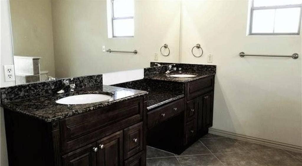 3713 Pearl Trail, Garland, TX 75044 Dual vanity with dark wood-finish cabinetry, stone countertops, and integrated sinks