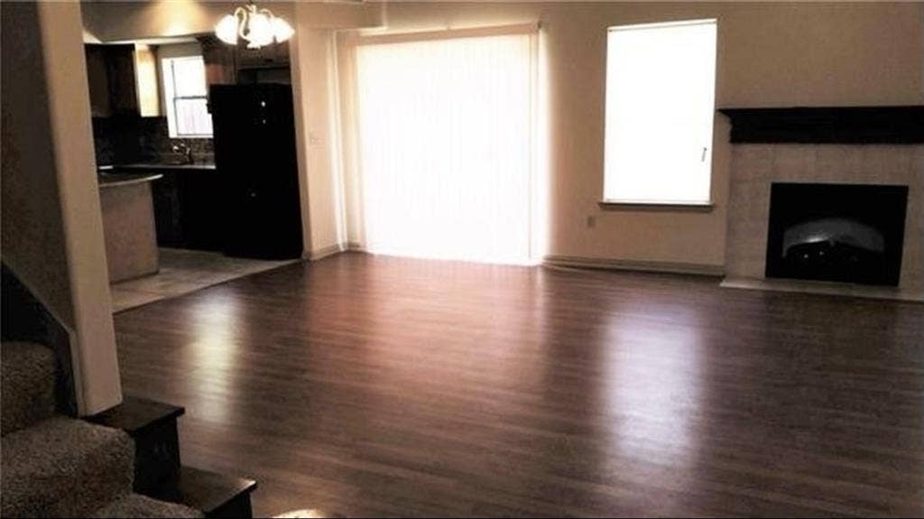 3713 Pearl Trail, Garland, TX 75044 Wood-finish flooring throughout, a tiled fireplace with mantel, and a sliding glass door