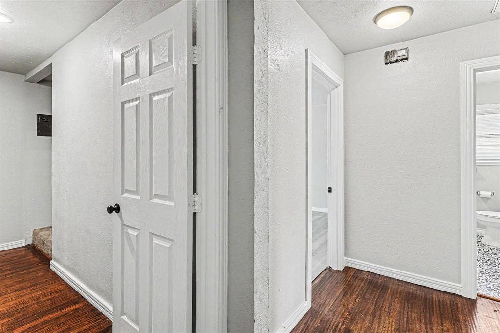 1108 E Robert Street, Fort Worth, TX 76104 Hardwood-finish flooring throughout, white paneled interior doors with matte black hardware, and an overhead flush-mount light fixture