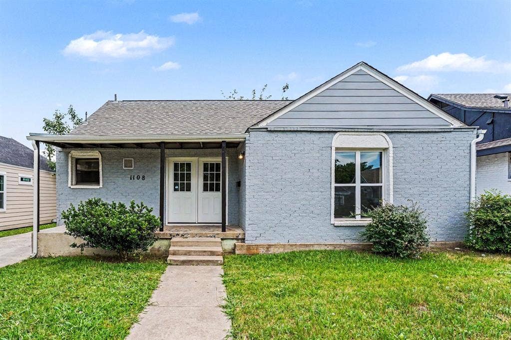 1108 E Robert Street, Fort Worth, TX 76104 Brick exterior with gabled roofline, covered front porch, double French-style entry doors, and a concrete walkway