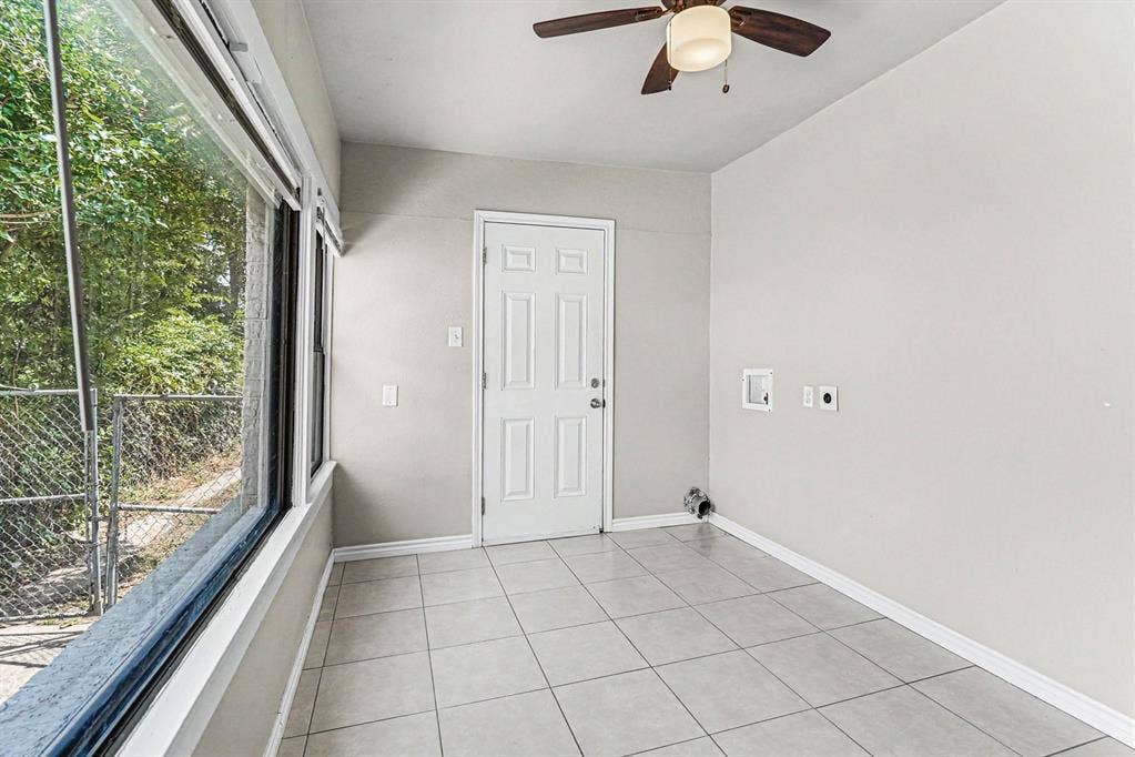 1108 E Robert Street, Fort Worth, TX 76104 Tile flooring, large window, ceiling fan, paneled door, and laundry connections