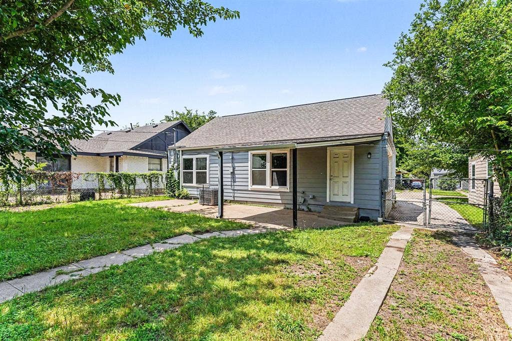 1108 E Robert Street, Fort Worth, TX 76104 Single-story residence featuring light blue siding, a covered front porch, and a gray shingle roof