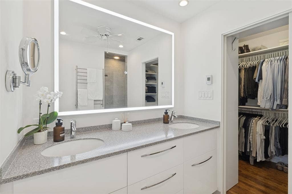 6719 Braeburn Drive, Dallas, TX 75214 Dual vanity with integrated sinks, granite countertop, and white cabinetry