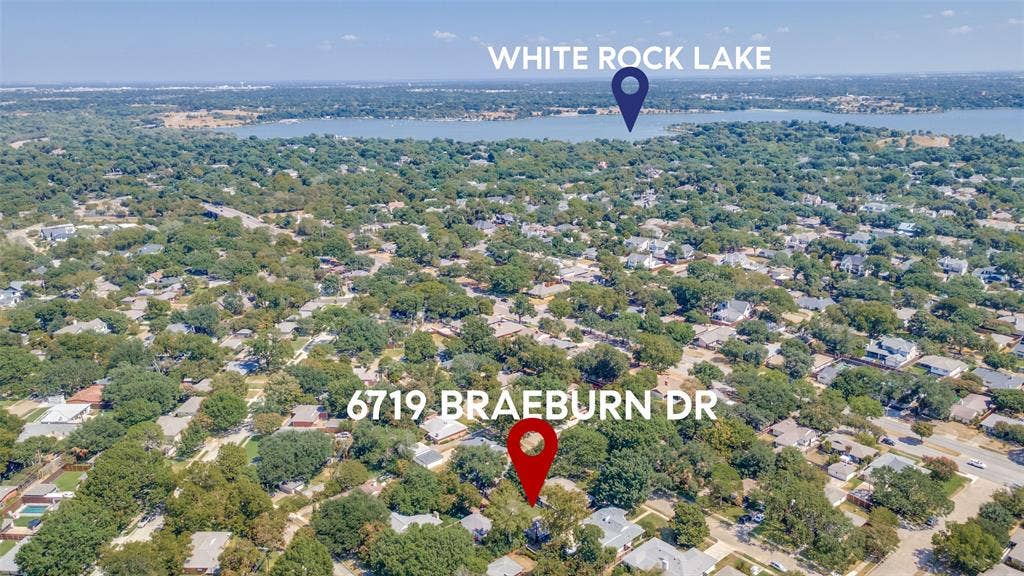 6719 Braeburn Drive, Dallas, TX 75214 Aerial perspective of a tree-lined residential area with a prominent body of water in the background