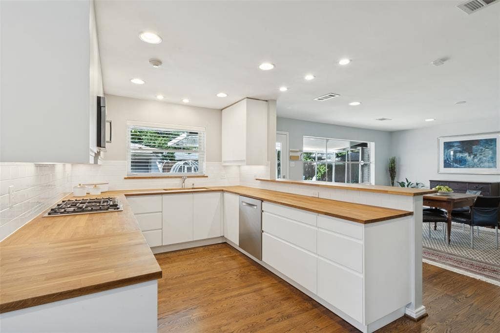 6719 Braeburn Drive, Dallas, TX 75214 Kitchen featuring wood-finish countertops, white flat-panel cabinetry, a stainless steel dishwasher, a gas cooktop, and recessed lighting
