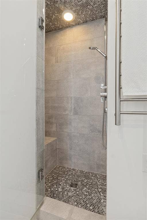 6719 Braeburn Drive, Dallas, TX 75214 Walk-in shower with tile surround, mosaic tile floor, built-in bench, and glass enclosure