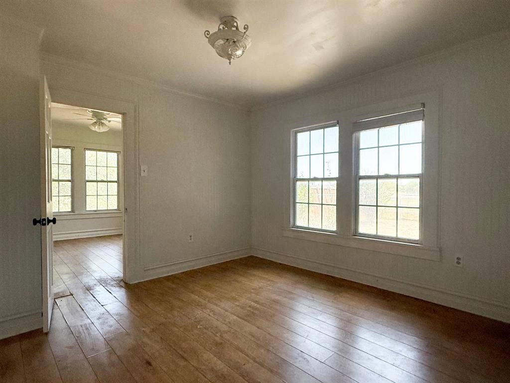 Hardwood flooring, double-hung windows, and a classic ceiling light fixture