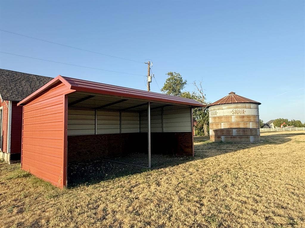 Red metal-sided carport with a corrugated metal roof