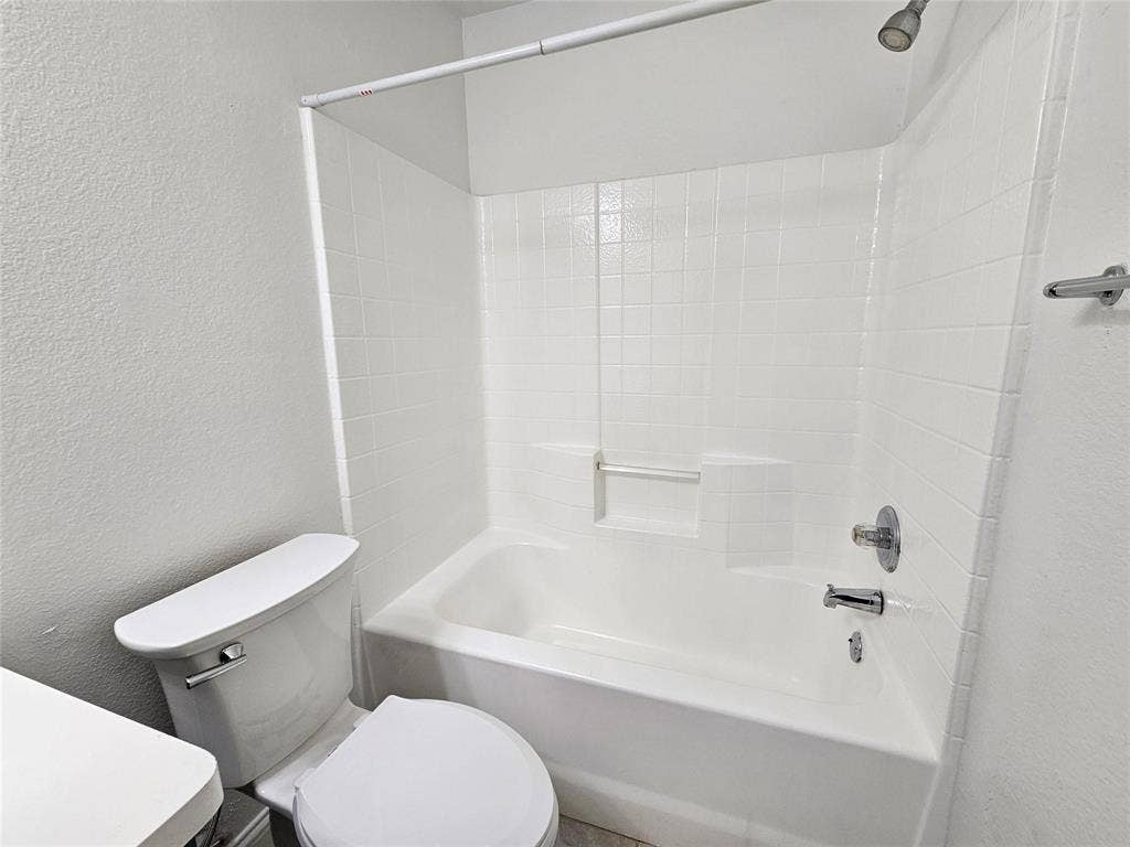 1615 Herald Street, #1613, Dallas, TX 75215 Tub/shower combination with white subway tile surround and chrome fixtures