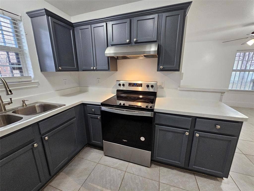 1615 Herald Street, #1613, Dallas, TX 75215 Kitchen featuring dark cabinetry, light countertops, stainless steel appliances, and a dual basin sink
