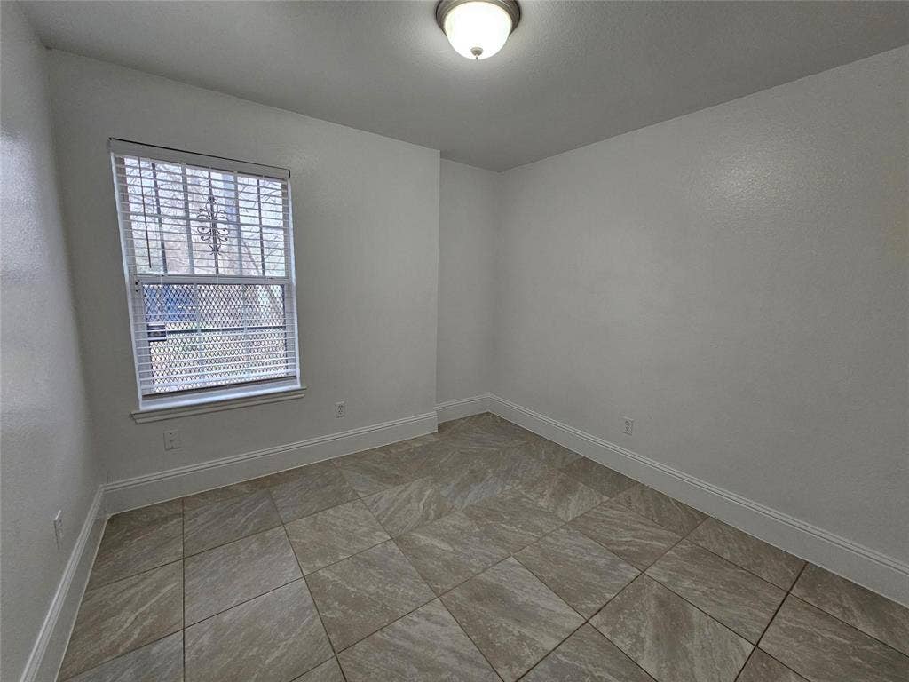 1615 Herald Street, #1613, Dallas, TX 75215 Neutral wall color with textured finish, tiled flooring, window with horizontal blinds, and a ceiling-mounted light fixture