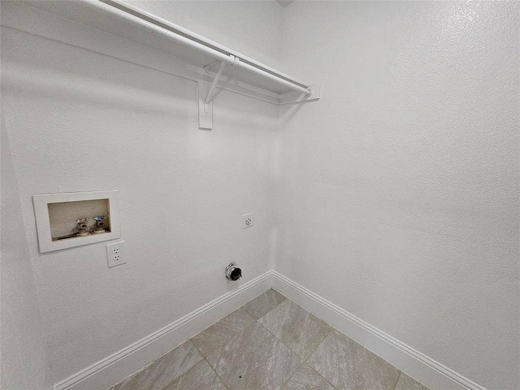 1615 Herald Street, #1613, Dallas, TX 75215 Laundry utility area with tile flooring and a wall-mounted clothing rod