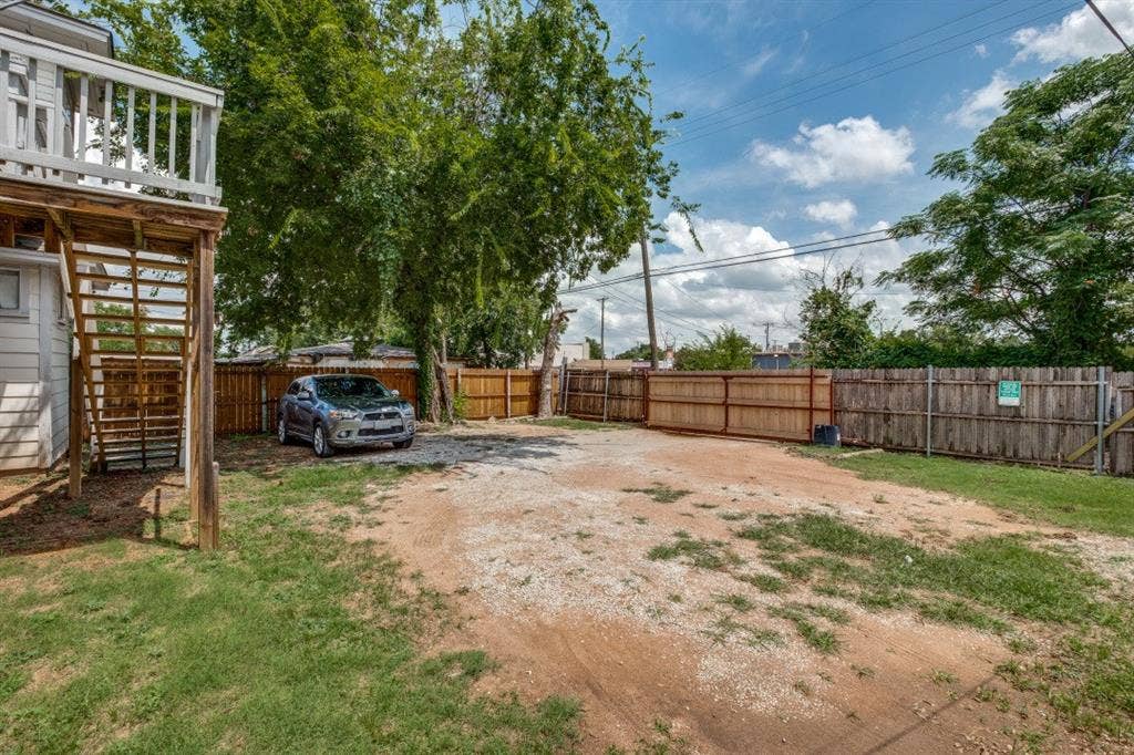 804 Sunset Avenue, #C, Dallas, TX 75208 Private backyard featuring wood fencing, mature trees, and a gravel parking area