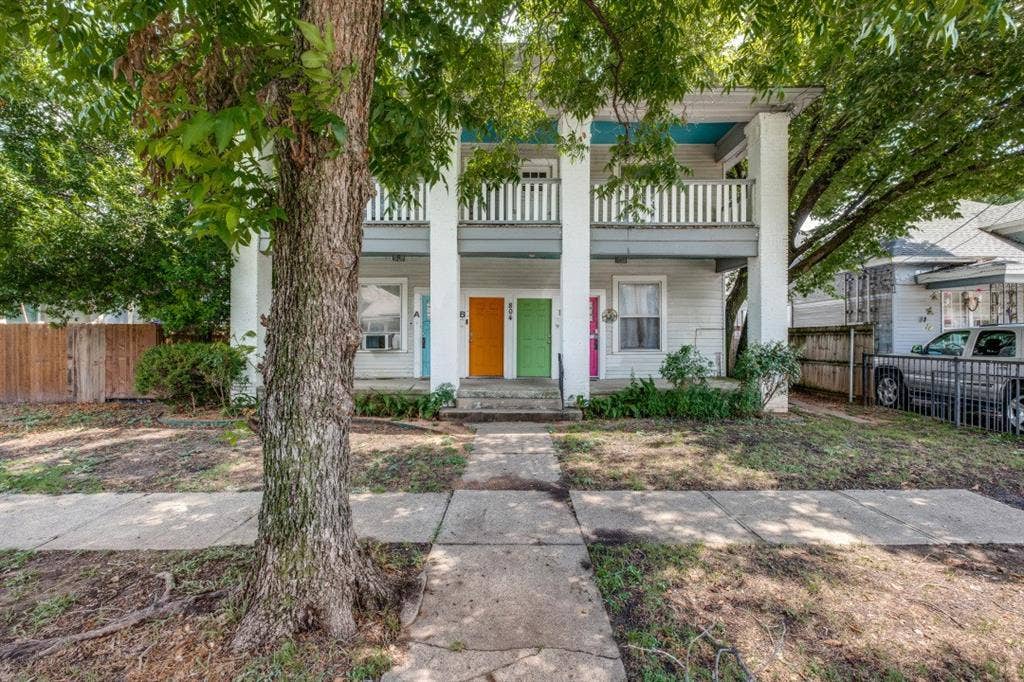 804 Sunset Avenue, #C, Dallas, TX 75208 Two-story exterior with a second-level balcony, multiple entry doors, and mature trees providing shade
