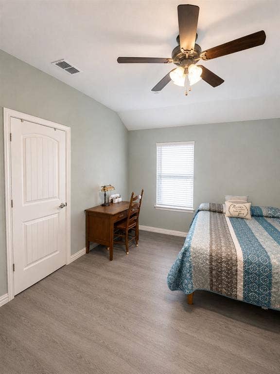 714 N Wofford Street, Athens, TX 75751 Wood-finish flooring, a ceiling fan with integrated lighting, a paneled interior door, and a window with horizontal blinds