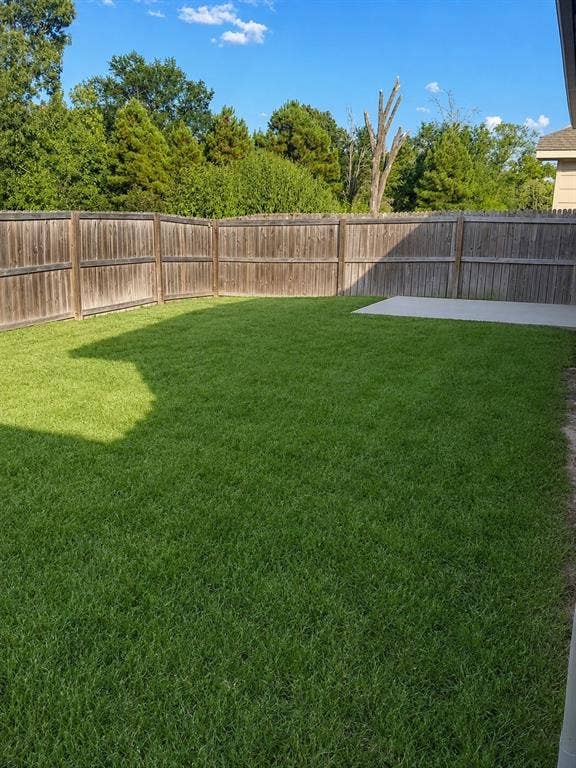 714 N Wofford Street, Athens, TX 75751 Expansive backyard featuring a lush lawn, privacy fencing, and a concrete patio