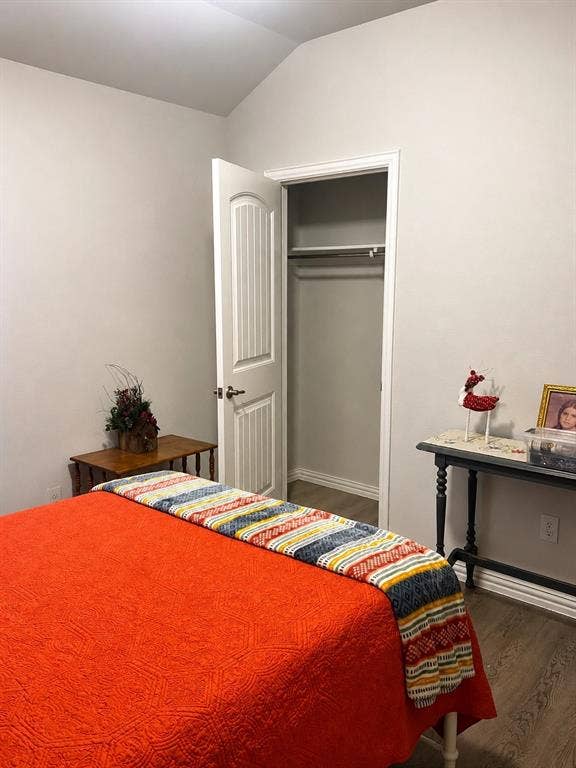 714 N Wofford Street, Athens, TX 75751 Vaulted ceiling, wood-finish flooring, interior door with paneling, and a built-in closet with hanging rod